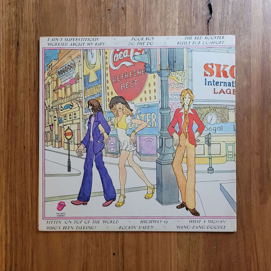 A vintage illustrated magazine or book titled 'Skate America International' lies flat on a wooden table. The cover features colorful cartoon-style drawings of people skateboarding in a city scene.