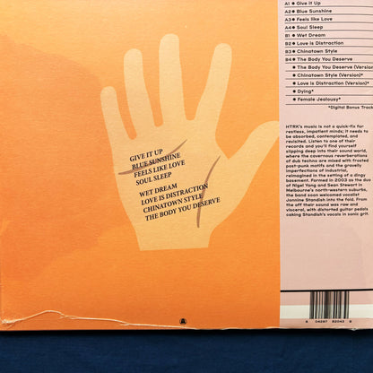 Back of vinyl record cover for HTRK's Psychic 9-5 cLUB with a hand line and text on an orange background