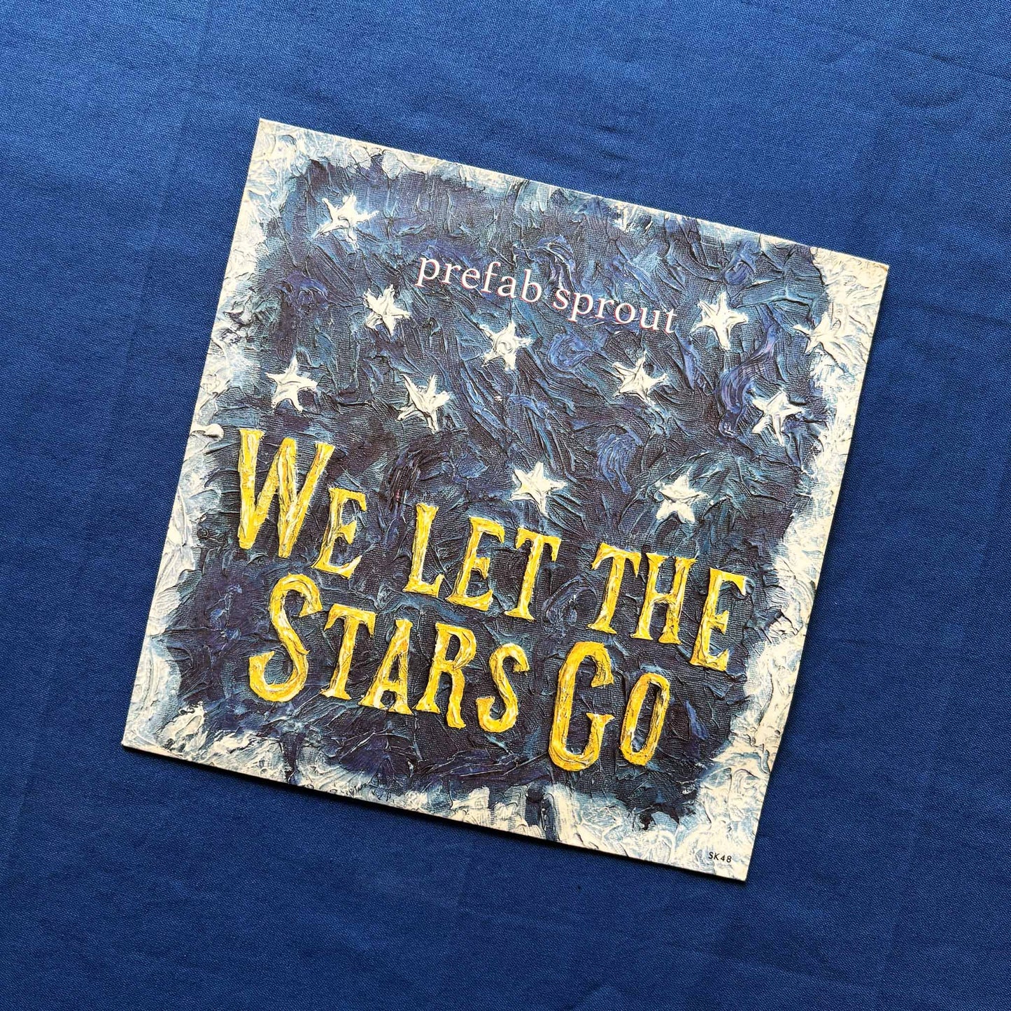 Album cover with 'We Let the Stars Go' text and star illustrations on a blue background