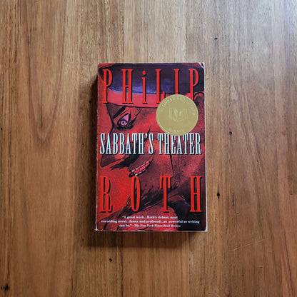 Philip Roth - Sabbath's Theater paperback book cover on wooden surface.