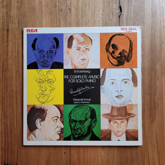 A square album cover for 'Schoenberg: The Complete Music for Solo Piano' by Nadual Fouse, released by RCA Red Seal, displayed flat on a wooden surface. The cover features a 3x3 grid of colorful portrait illustrations in blue, orange, yellow, green, black, and white.