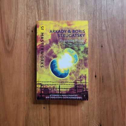 Arkady & Boris Strugatsky - Roadside Picnic book cover illustration on wooden surface
