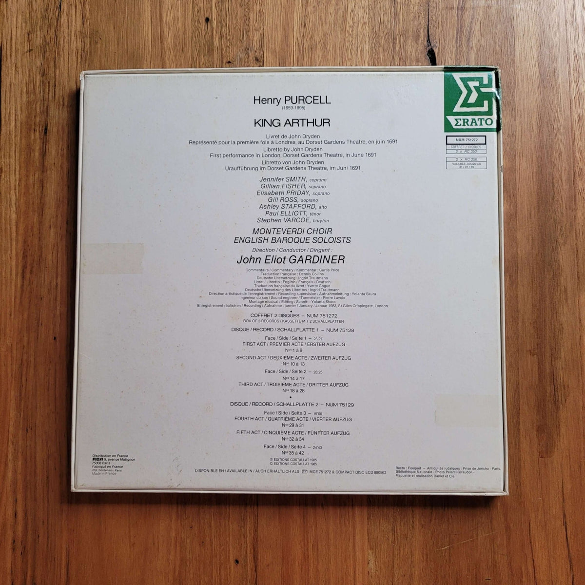 The back cover of a Erato Records vinyl record for Henry Purcell's King Arthur, featuring track listings and the Erato logo, placed on a wooden surface.