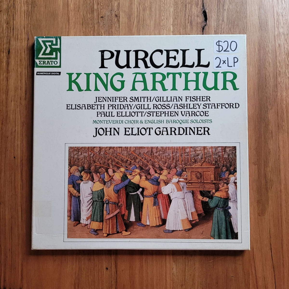 A 2 LP CD album cover for 'Purcell: King Arthur' on Erato Records, placed flat on a wooden surface. The cover features a white background with green and black text, a central medieval scene illustration, and a green Erato logo in the top left corner.