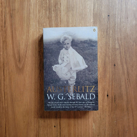W. G. Sebald - Austerlitz (Paperback) cover with a child in historical attire on wooden background.
