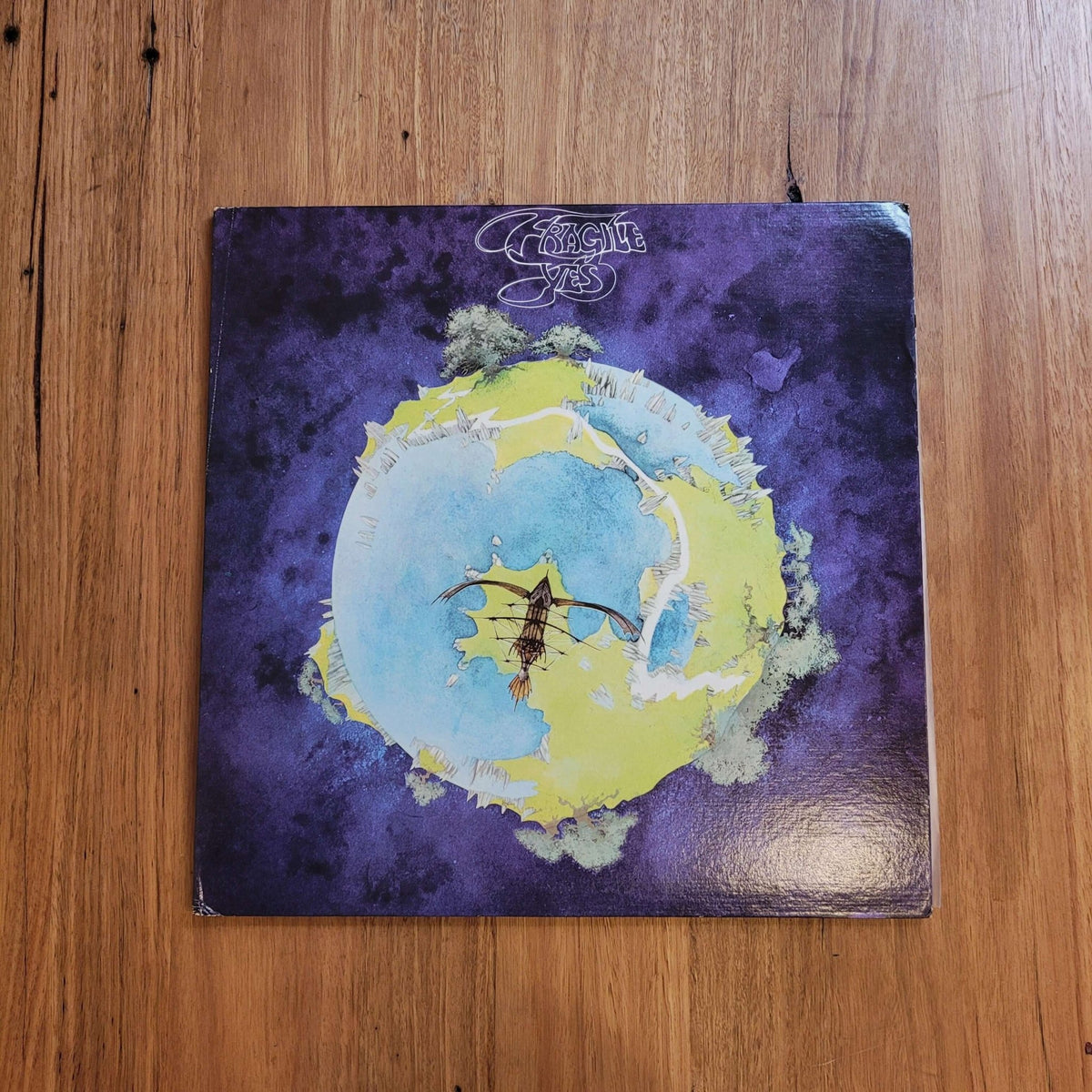 Yes - Fragile album cover art from 1971, showcasing colorful design and iconic logo on a wooden background.